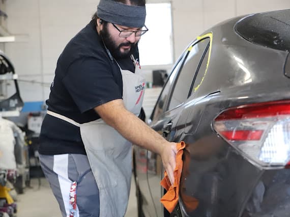 Auto body technician working on vehicle door at Best Class Auto Body Las Vegas